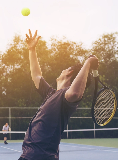 A man serves a tennis ball while enjoying villa amenities